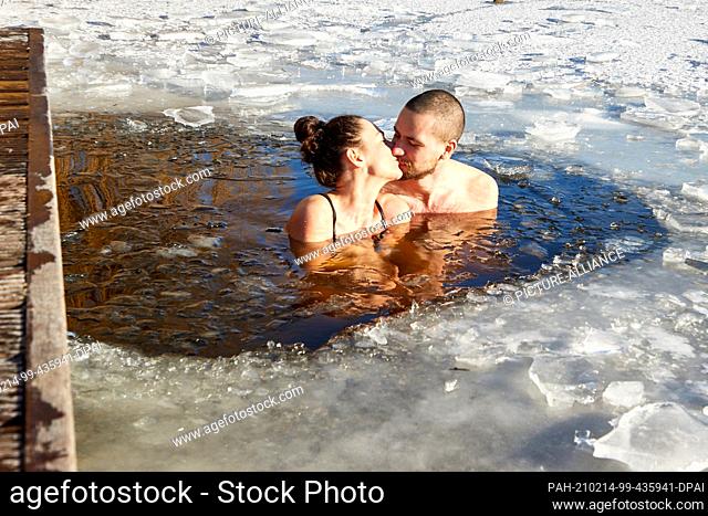 14 February 2021, Hamburg: Kristyna Amanatidu and Ondrej Keves kiss while ice bathing in the city park lake on Valentine's Day. Photo: Georg Wendt/dpa