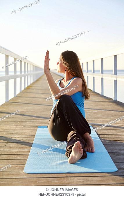 Pregnant woman practicing yoga at seaside