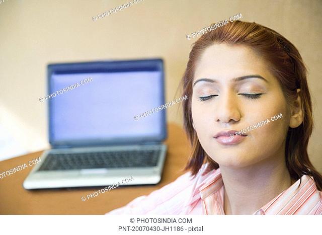 Close-up of a businesswoman with a laptop in the background