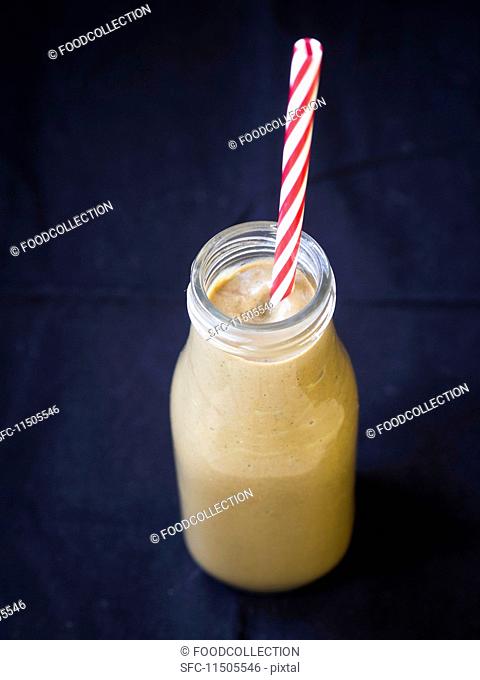 A vegan avocado and chocolate smoothie in a bottle with a straw