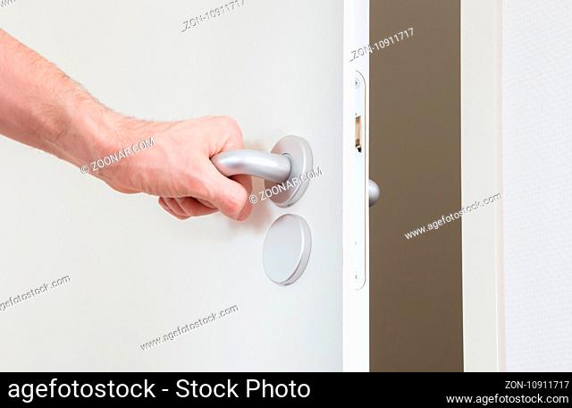 White door with chrome doorhandle, selective focus