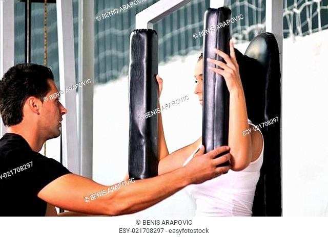 woman in the fitness gim working out with personal trainer