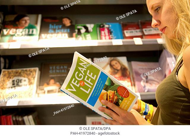 A woman reads a vegan cookbook in the vegan supermarket 'Veganz' in Berlin, Germany, 22 August 2013. Photo: Ole Spata | usage worldwide