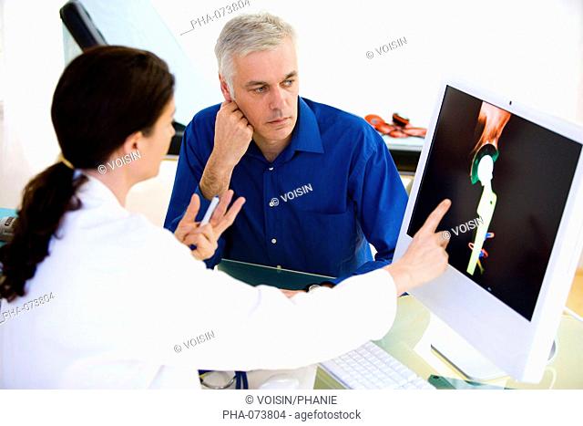 Doctor discussing hip replacement X-ray with a patient