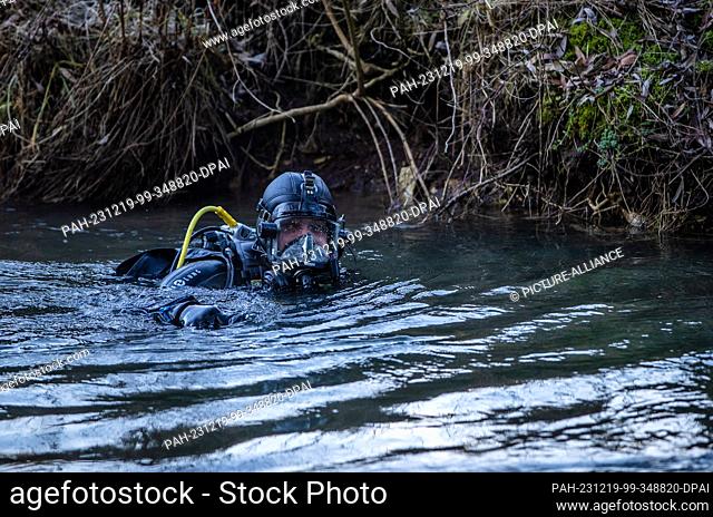 19 December 2023, Baden-Württemberg, Bingen-Hitzkofen: A police diver is searching the waters of the Lauchert for a two-year-old child who has been missing...