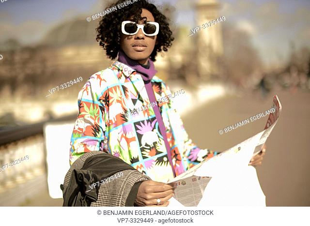 young fashion model man with city map, in Paris, France