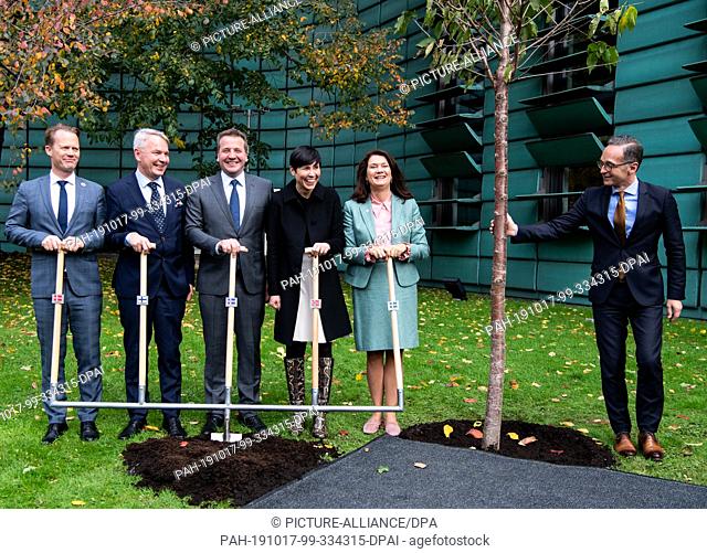 17 October 2019, Berlin: Heiko Maas (r, SPD), Foreign Minister, is symbolically planting a tree at the 20th anniversary celebrations of the Nordic Embassies in...