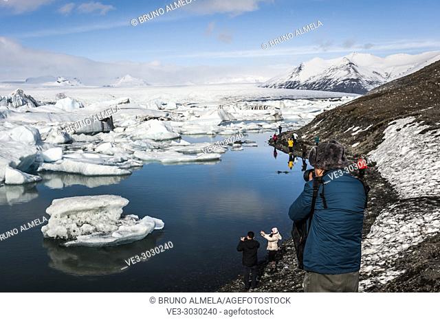 Tourists taking pictures to icebergs in Jökulsárlón Glacier Lagoon, Breidamerkurjökull Glacier (region of Austurland, Iceland)