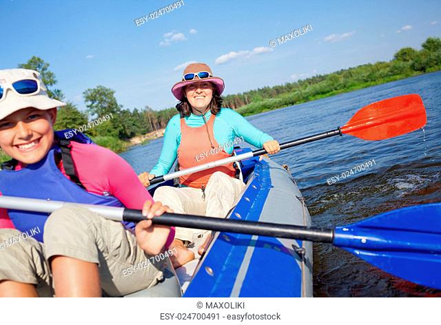 Summer vacation - Happy woman with her daughter kayaking on river