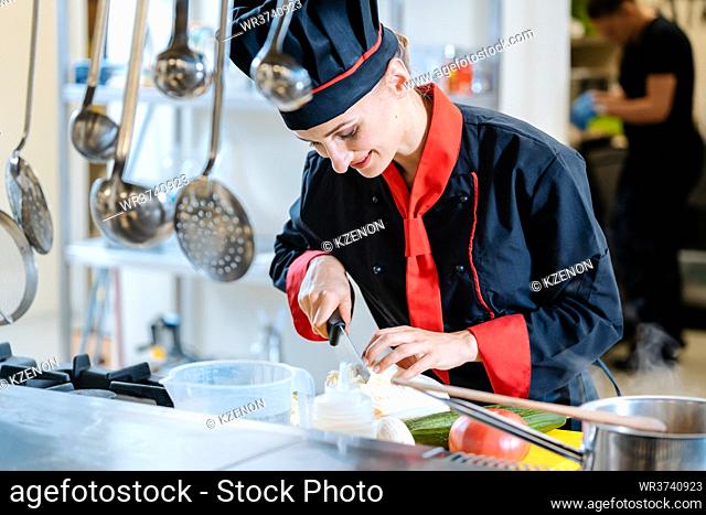 A female chef slicing cauliflower in pieces for a meal
