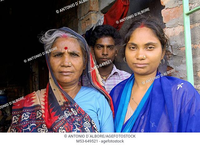a mother, doughter and son on the doorstep of their home in dhapa district. kolkata. west bengal. india. asia