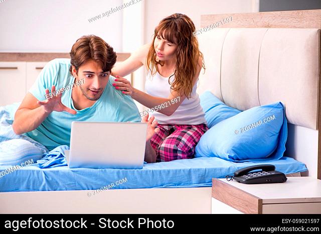 Young couple with laptop in the bedroom