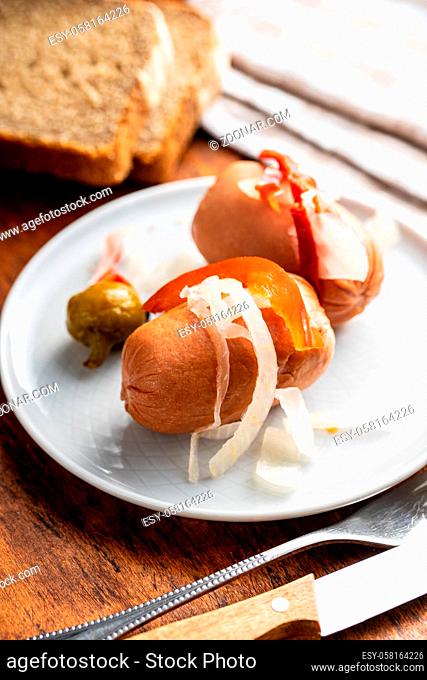 Pickled sausages with onion and red pepper. Marinated food on plate