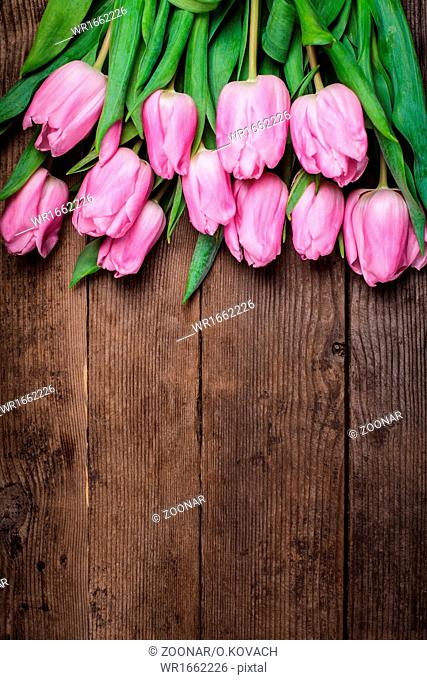 Pink tulips over wooden table