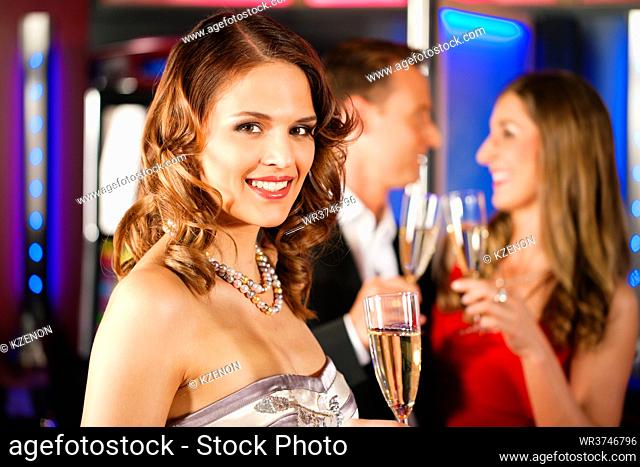 Three friends with champagne in a bar or casino