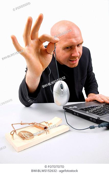 bald headed man holding a computer mouse over mouse trap