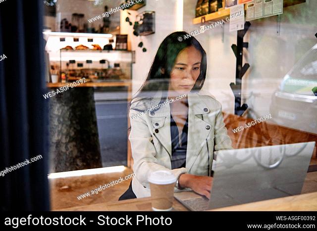 Woman using laptop at coffee shop