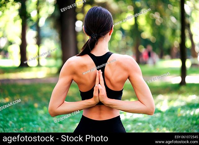 Athletic young woman doing yoga in the Park in the morning, women's training on a yoga Mat