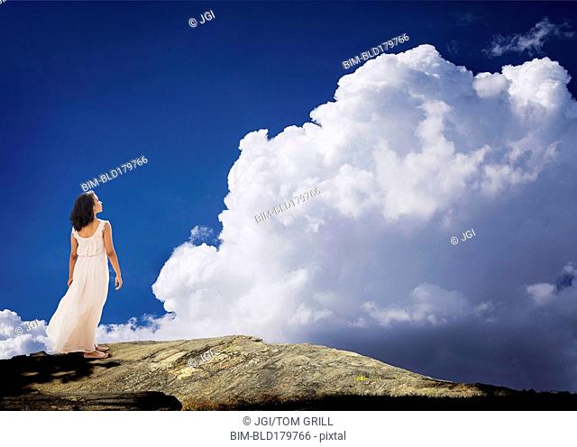 Mixed race woman standing on mountaintop