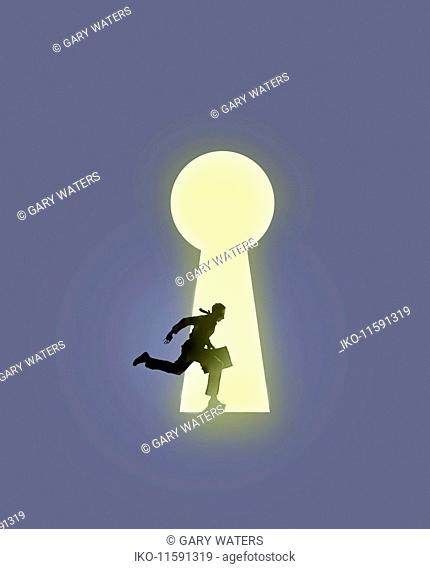 Businessman running into large illuminated keyhole