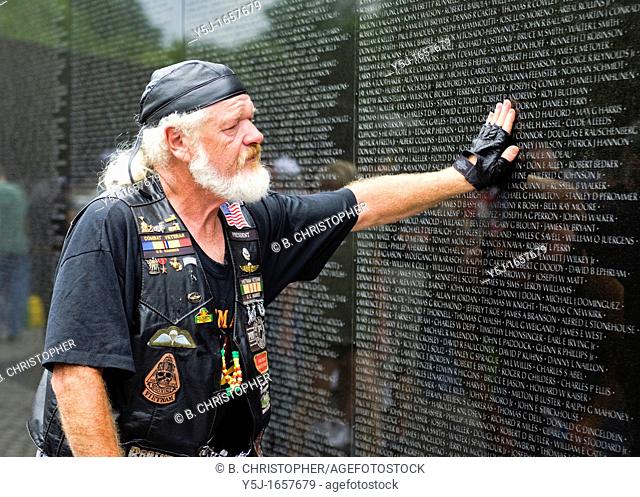 Vietnam veteran pays respect to fallen soldiers at the Vietnam War Memorial - Washington, DC