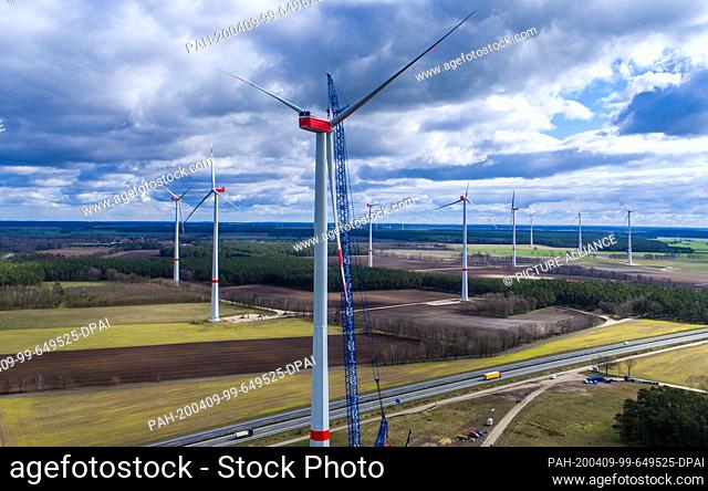 31 March 2020, Mecklenburg-Western Pomerania, Hoort: A special crane is used to lift the pre-assembled propeller to the nacelle of a wind turbine