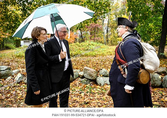 31 October 2019, US, Boston: Federal President Frank-Walter Steinmeier and his wife Elke Büdenbender are greeted by a ranger wearing a historical militia...