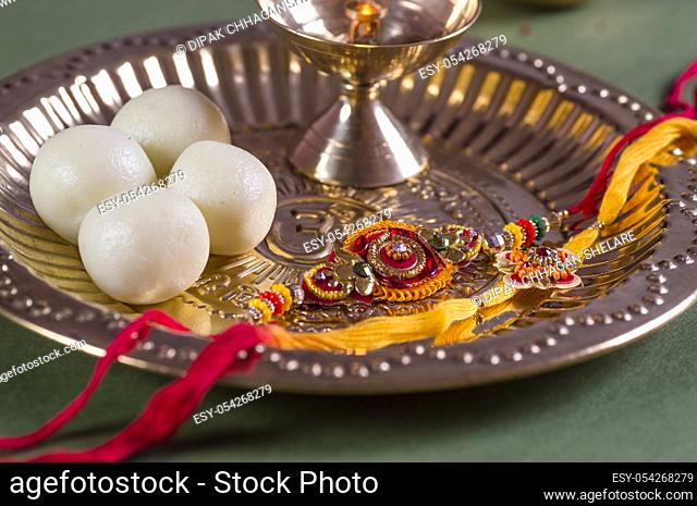 Indian Festival: Raksha Bandhan or Rakhi background with an elegant Rakhi and diya