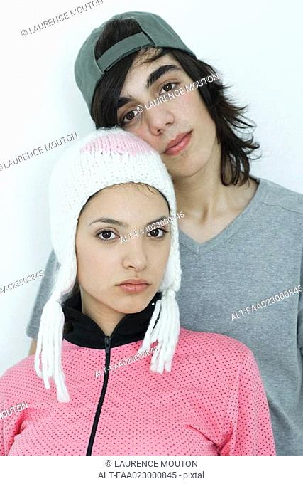 Young couple wearing hats, looking at camera, portrait