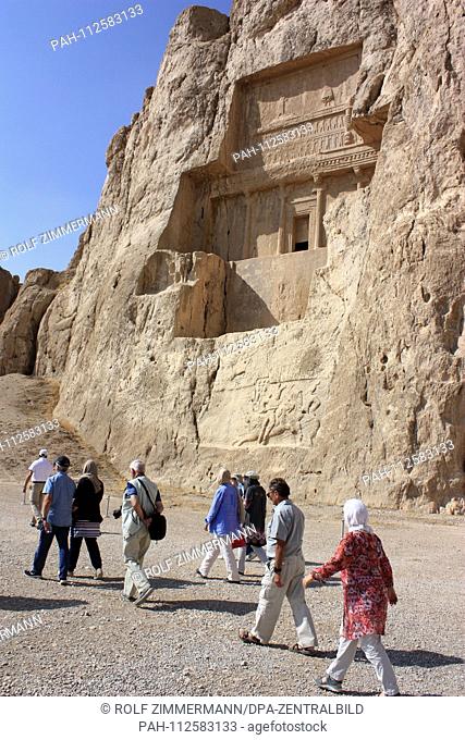 Iran - tourist group in front of the cruciform rock tomb of King Dareios II in Naqsh-e Rostam, Fars province, north of Persepolis. Taken on 19.10.2018