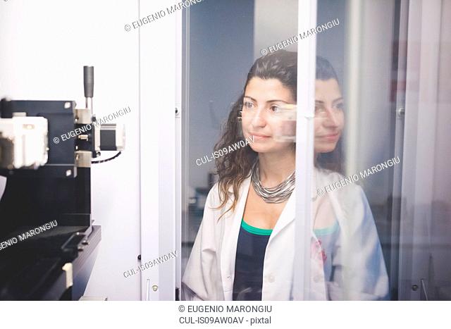 Female scientist monitoring motor alignment on x-ray diffractometer machine