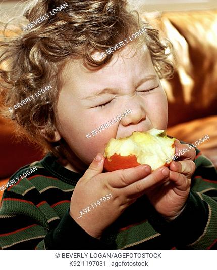 Young child eating an apple
