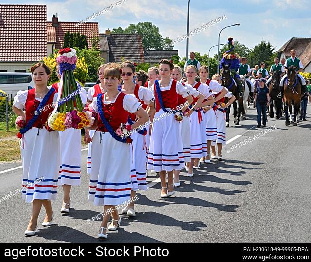 18 June 2023, Brandenburg, Casel: In the procession of St. John's riding girls wear a crown, while behind them rides St. John