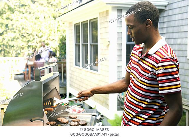 Young African man barbecuing food