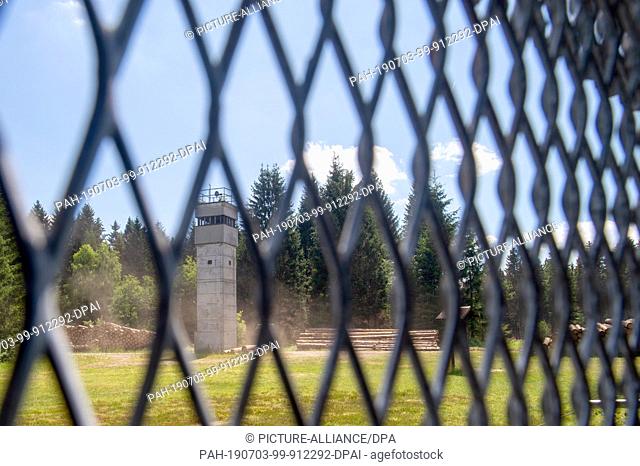 01 July 2019, Saxony-Anhalt, Sorge: View through the old border fence to a former watchtower in the border museum. The museum is located directly on the Green...