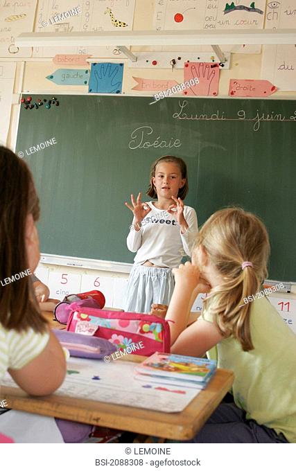 SCHOOLCHILD Schoolgirl in 1st grade reciting a lesson or a poetry