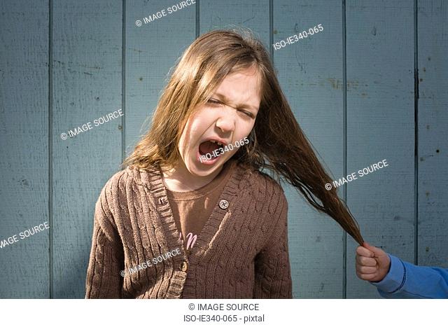 Girl having hair pulled