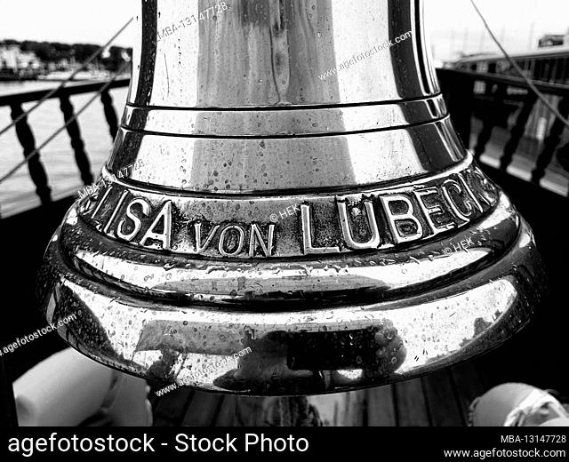 a tourist is reflected in the bell of the historic merchant ship Lisa von Lübeck while taking photos
