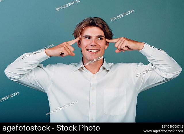 Portrait european young positive thinking man portrait with hand fingers at head