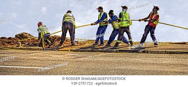 A team of men working. Pulling through fibre optic cable connection. Cape Town, South Africa