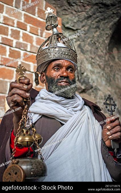 Portrait of an ethiopian orthodox priest holding a cross in nakuto lab cave church, Amhara region, Lalibela, Ethiopia