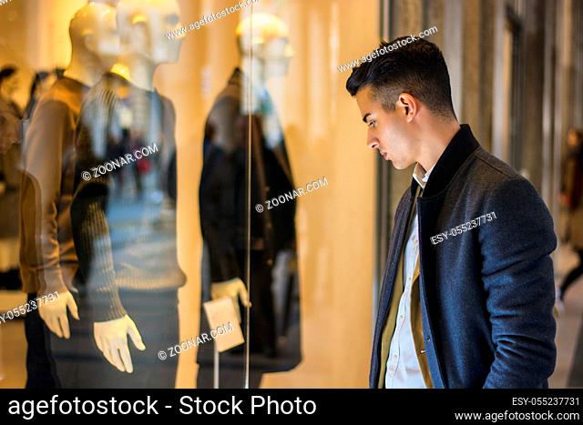 Handsome Young Man in Black Elegant Suit Looking at Displayed Fashion Items in Glass Window Boutique at the High Street Side
