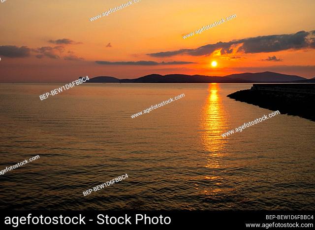 Summer sunset landscape over the Gulf of Alghero at Mediterranean Sea - Sardinia, Italy - with cliffs of Capo Caccia cape and Porto Conte Nature Reserve in...
