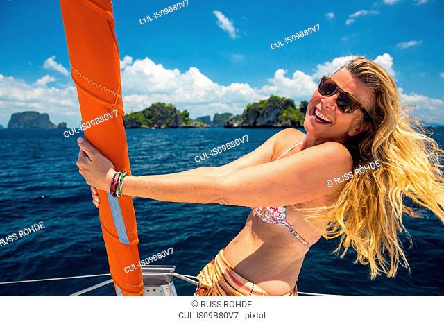 Portrait of woman on yacht looking at camera smiling, Koh Pak Ka, Krabi, Thailand, Asia