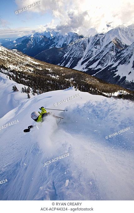 A young male skier slashes a powder turn, Kicking Horse Resort, Britsh Columbia, Canada