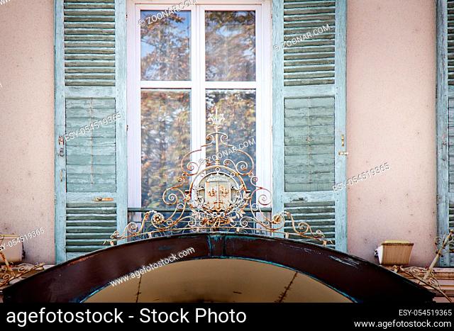 Limoges, France - September 28, 2017: front entrance, window, and wrought-iron knight coat of arms with sword and lilies