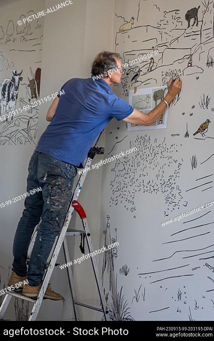 PRODUCTION - 04 September 2023, Brandenburg, Dallgow-Döberitz: The theater painter Mario Kwast paints the walls of the exhibition rooms of the nature experience...