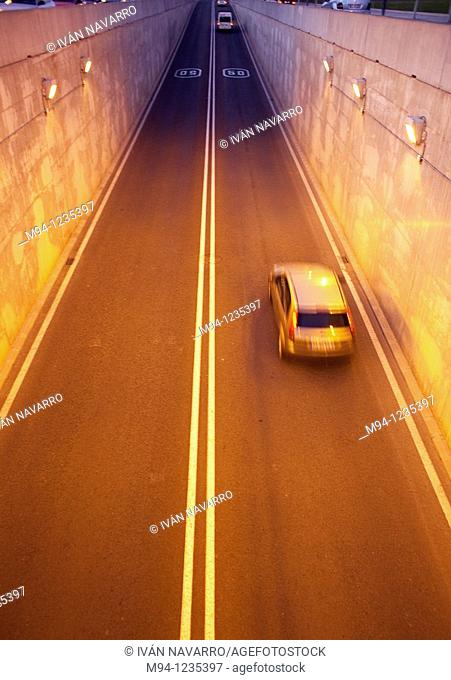 cars and motorcycles passing through a tunnel