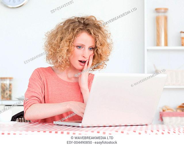 Good looking blonde female relaxing with her laptop while sittin