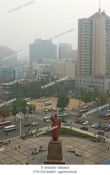 Cityscape of Dandong with the monument of former Chairman Mao in foreground, Dandong, Liaoning Province, China